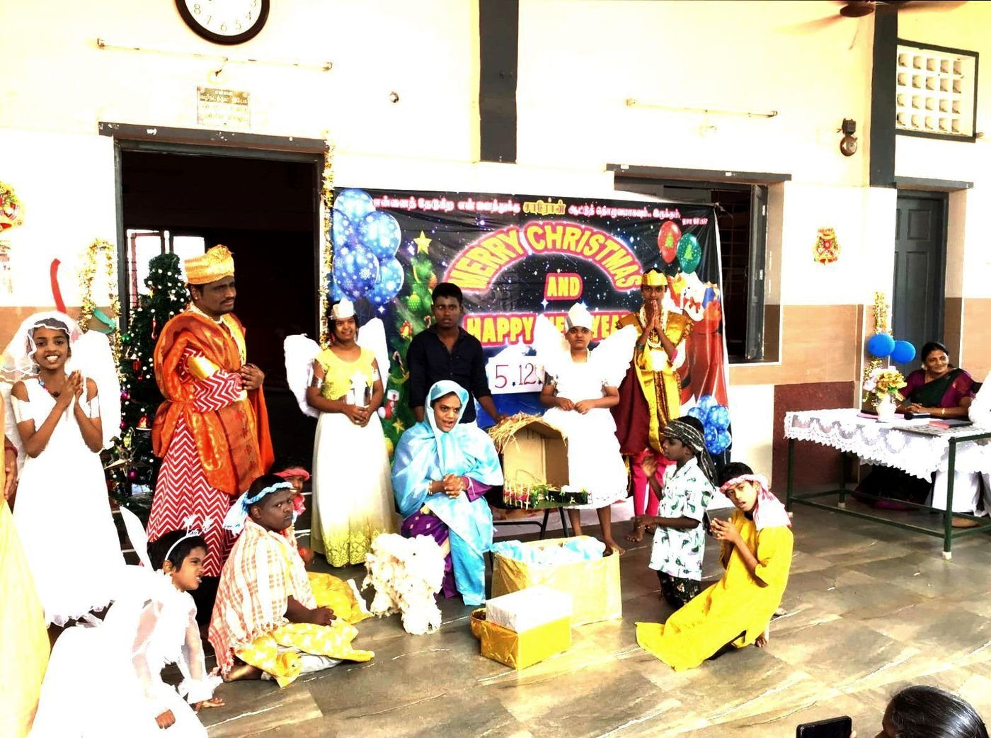 Students in costume perform a nativity play in the school hall at Christmas